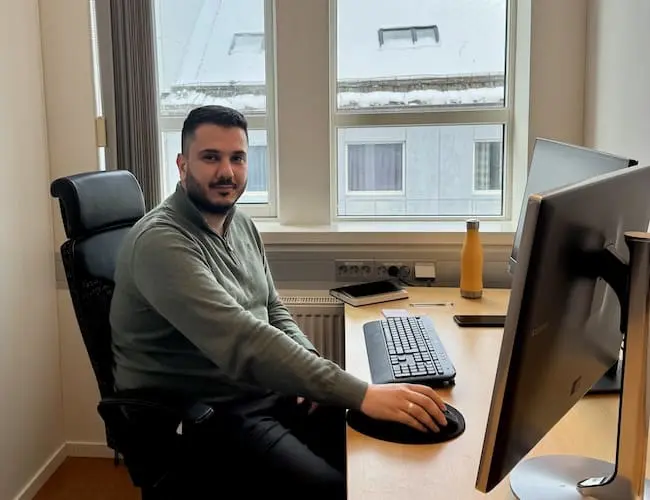 Mann som sitter ved skrivebord