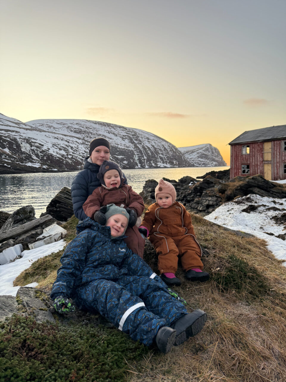 Søsken som sitter på bakken ute